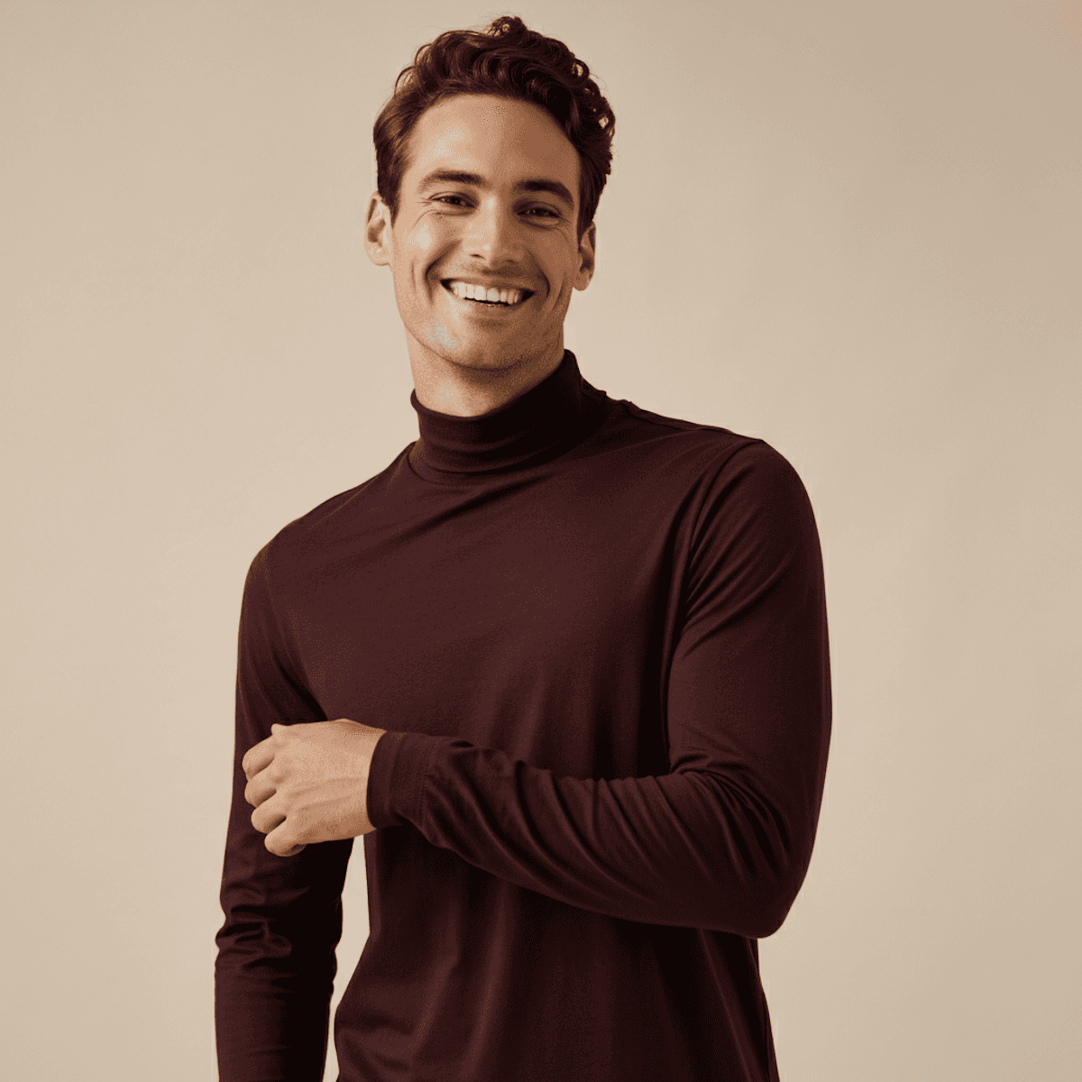 Smiling young man wearing a maroon turtleneck in a professional studio portrait.